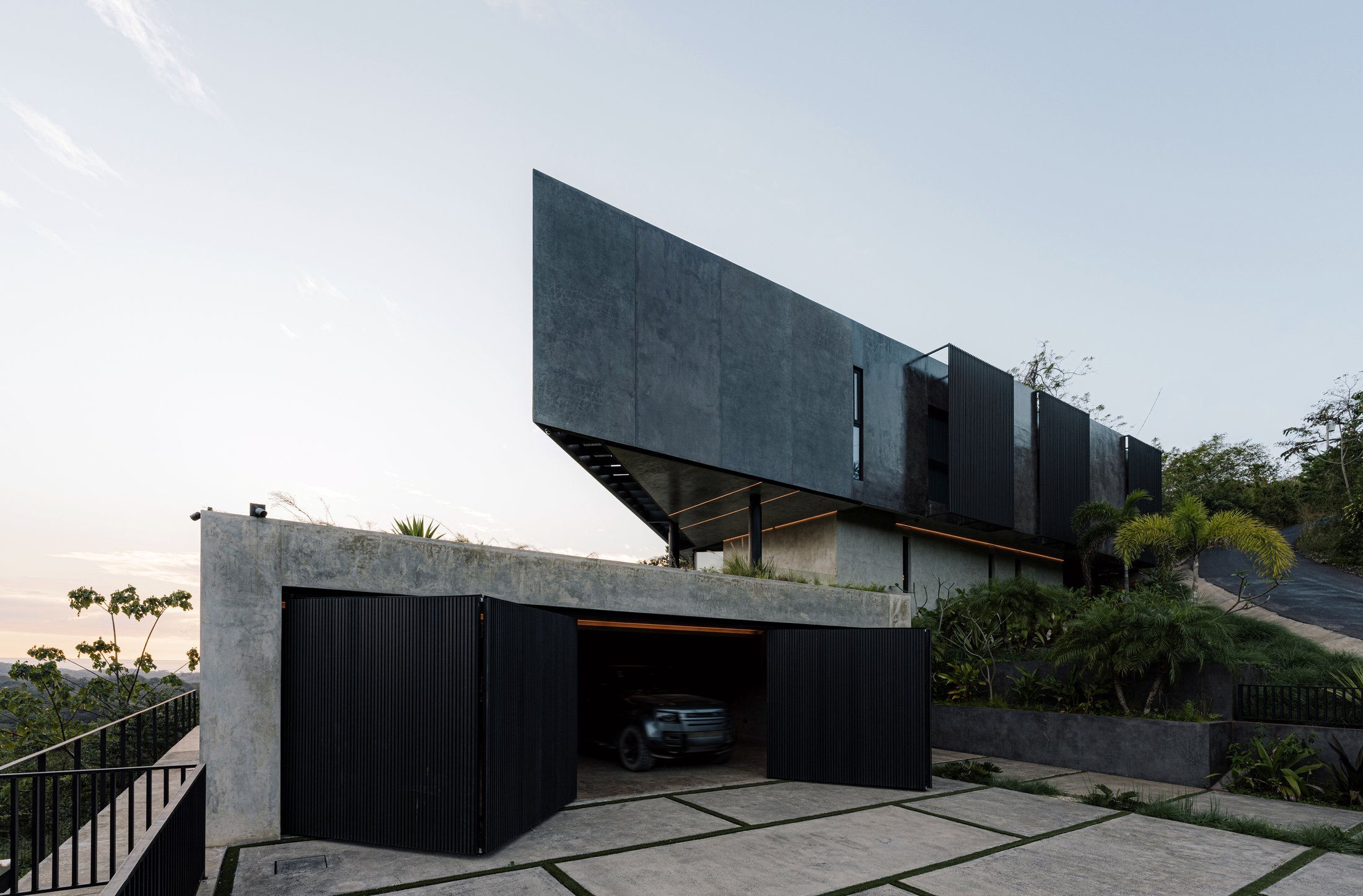 Fachada de Casa Cinco 7 al atardecer, con el volumen superior en voladizo