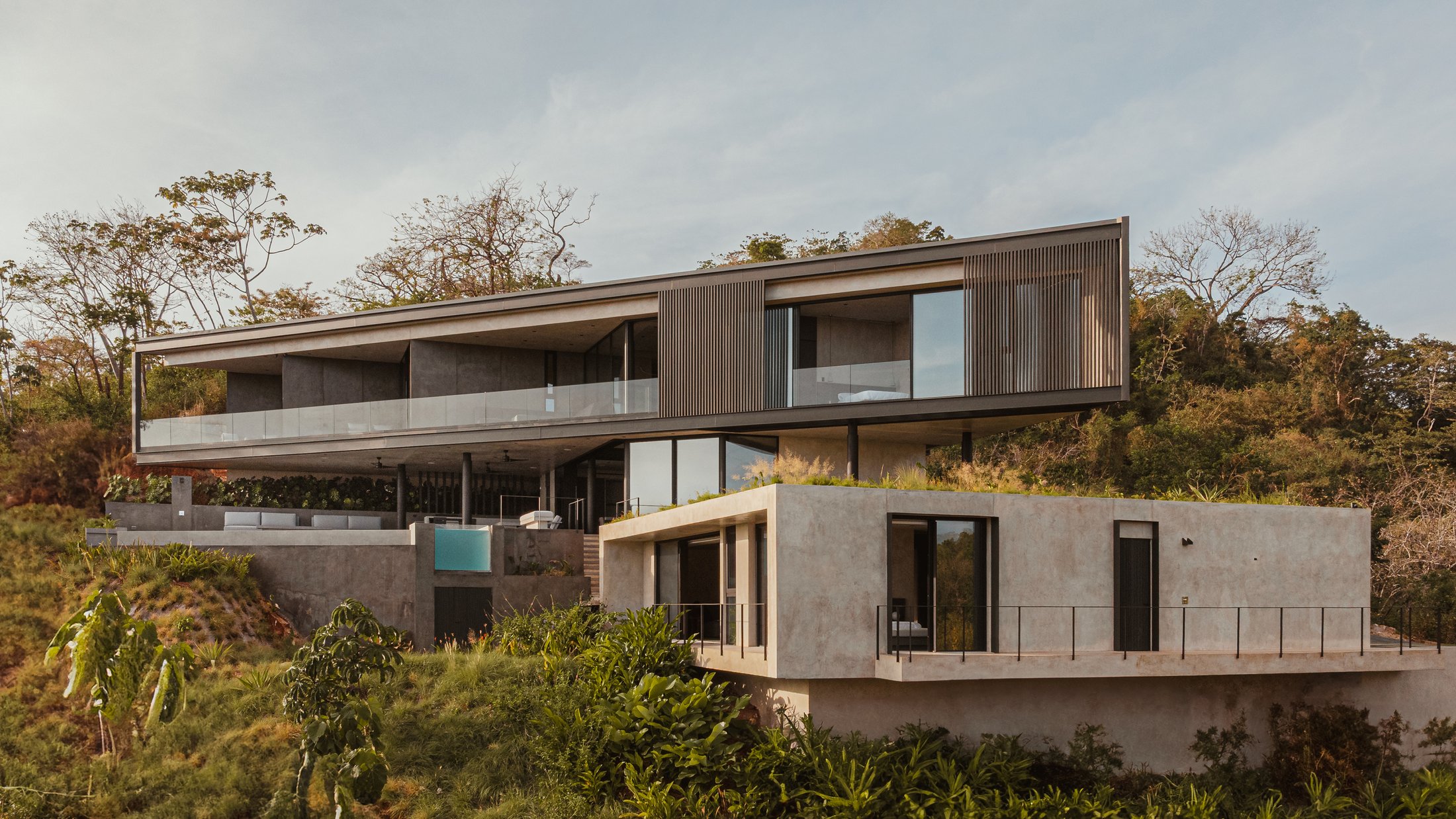 Casa Cinco 7 al atardecer, volumenes escalonados sobre la pendiente
