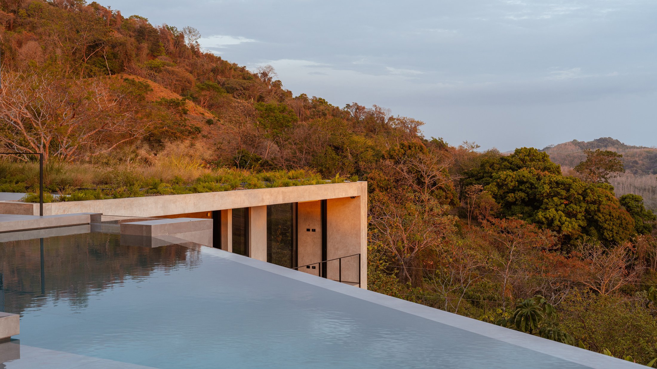 Piscina infinita de Casa Cinco 7 con vista a las colinas de Nosara