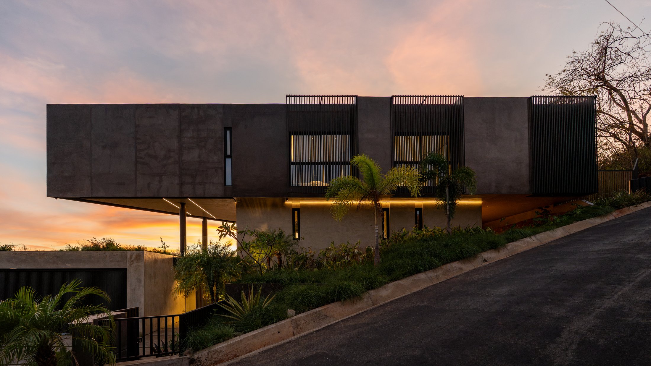 Casa Cinco 7 iluminada al anochecer, vista desde el acceso